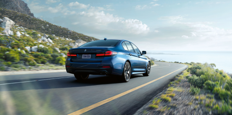 Blue Sedan Driving Near Ocean