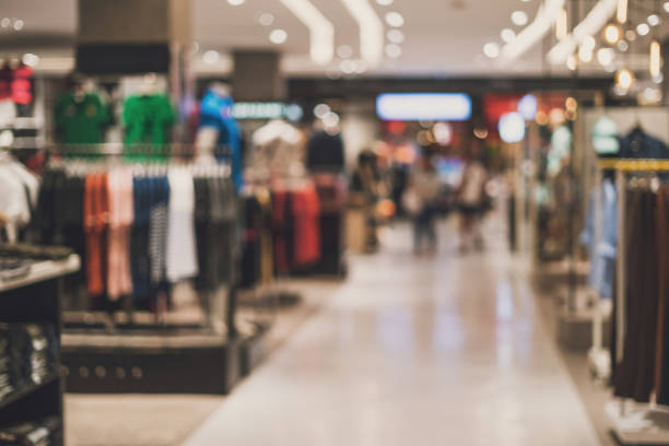 blurred photo of racks of retail products (such as clothes) inside of a mall